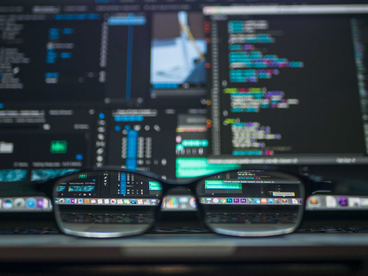 gallery-02 Eyeglasses reflecting computer code on a monitor, ideal for technology and programming themes.